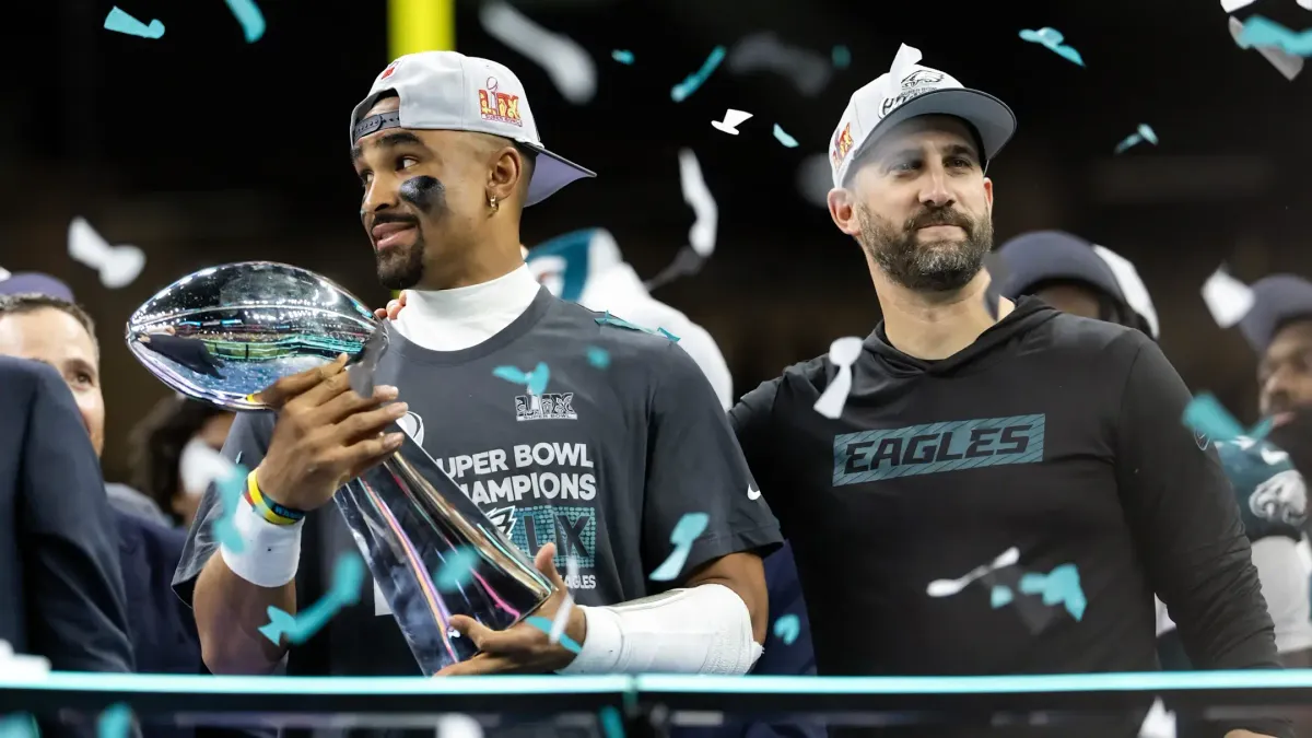 Quarterback Jalen Hurts e técnico Nick Sirianni, do Philadelphia Eagles, comemoram com o troféu Vince Lombardi após a conquista do Super Bowl. Foto: Mark J. Rebilas / Imagn Images